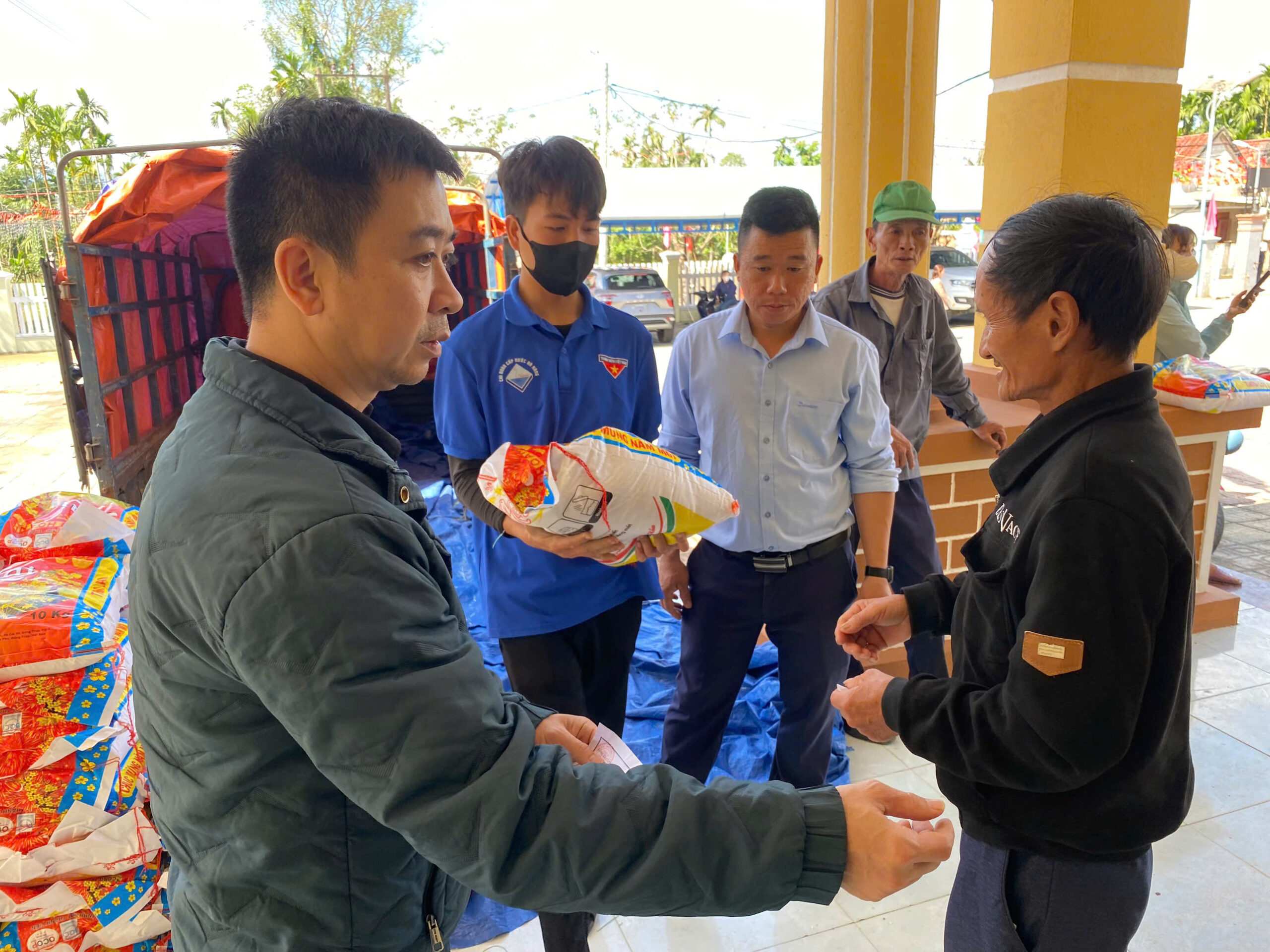 Đoàn viên công ty hỗ trợ trao quà cho bà con